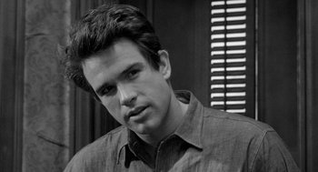 Movie still from “Mickey One” (1965), directed by Arthur Penn – Black and white photograph of a young man in a brown shirt; Close Up shot, Over the shoulder angle