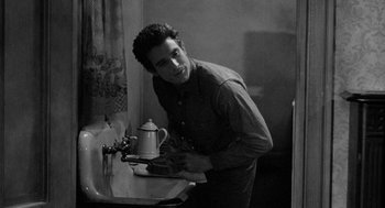 Movie still from “Mickey One” (1965), directed by Arthur Penn – A young man standing in front of a bathroom sink; Medium shot, High angle