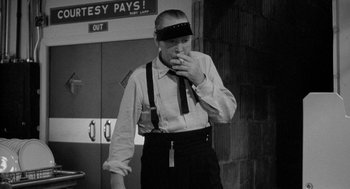 Movie still from “Mickey One” (1965), directed by Arthur Penn – A black and white photo of a man smoking a cigarette; Medium shot, Low angle