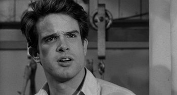 Movie still from “Mickey One” (1965), directed by Arthur Penn – Black and white photograph of a man looking at the camera; Close Up shot, Over the shoulder angle