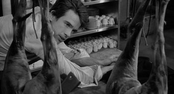 Movie still from “Mickey One” (1965), directed by Arthur Penn – A man leaning on a shelf in a kitchen; Close Up shot, High angle