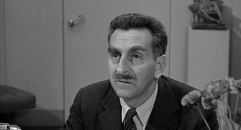 Movie still from “Mickey One” (1965), directed by Arthur Penn – An older man wearing a suit and tie; Close Up shot, Low angle