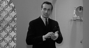 Movie still from “Mickey One” (1965), directed by Arthur Penn – A black and white photo of a man in a suit and tie; Medium shot, Low angle