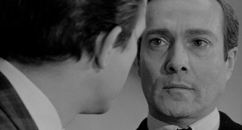 Movie still from “Mickey One” (1965), directed by Arthur Penn – A black - and - white photo of a man looking at a boy; Close Up shot, Over the shoulder angle