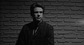 Movie still from “Mickey One” (1965), directed by Arthur Penn – Black and white photograph of a man wearing a suit; Close Up shot, Low angle