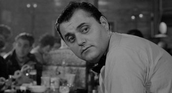 Movie still from “Mickey One” (1965), directed by Arthur Penn – Black and white photograph of a man with a bow tie; Close Up shot, Low angle