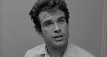 Movie still from “Mickey One” (1965), directed by Arthur Penn – Black and white photograph of a young man looking at the camera; Close Up shot, Low angle