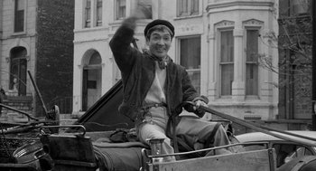 Movie still from “Mickey One” (1965), directed by Arthur Penn – An old photo of a man riding a horse drawn carriage; Medium shot, Low angle