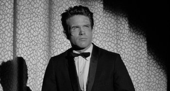 Movie still from “Mickey One” (1965), directed by Arthur Penn – A black and white photo of a man in a tuxedo; Close Up shot, Low angle