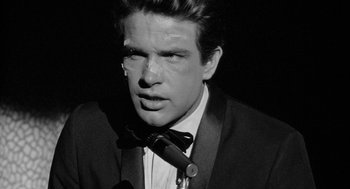 Movie still from “Mickey One” (1965), directed by Arthur Penn – A black and white photo of a man in a suit and bow tie; Close Up shot, Low angle