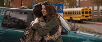 Movie still from “Middle School: The Worst Years of My Life” (2016), directed by Steve Carr – A woman hugging a man in front of a green car; Medium shot, Over the shoulder angle