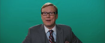 Movie still from “Middle School: The Worst Years of My Life” (2016), directed by Steve Carr – A man wearing a suit and tie and glasses; Close Up shot, Over the shoulder angle