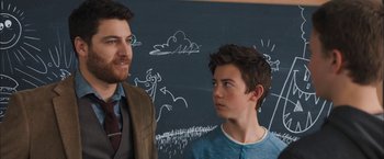 Movie still from “Middle School: The Worst Years of My Life” (2016), directed by Steve Carr – A man standing next to a boy in front of a chalkboard; Medium shot, Over the shoulder angle