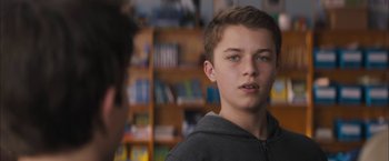 Movie still from “Middle School: The Worst Years of My Life” (2016), directed by Steve Carr – A young man standing in front of a bookshelf; Close Up shot, Over the shoulder angle