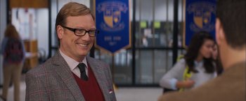 Movie still from “Middle School: The Worst Years of My Life” (2016), directed by Steve Carr – A man in a suit and tie smiling for the camera; Close Up shot, Over the shoulder angle