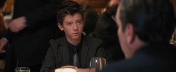 Movie still from “Middle School: The Worst Years of My Life” (2016), directed by Steve Carr – A young man sitting at a table with a glass of wine in front of him; Close Up shot, Over the shoulder angle
