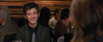 Movie still from “Middle School: The Worst Years of My Life” (2016), directed by Steve Carr – A young man sitting in front of a group of people in a room; Medium shot, Over the shoulder angle