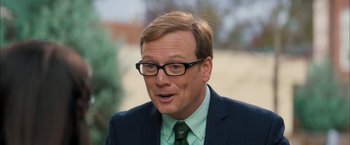 Movie still from “Middle School: The Worst Years of My Life” (2016), directed by Steve Carr – A person wearing glasses and a suit; Close Up shot, Over the shoulder angle
