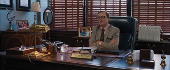 Movie still from “Middle School: The Worst Years of My Life” (2016), directed by Steve Carr – A man sitting at a desk in front of a camera; Medium shot, Over the shoulder angle