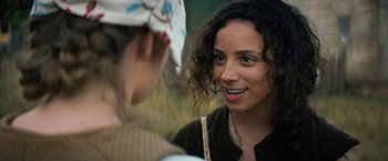 Movie still from “Fear Street: Part Three - 1666” (2021), directed by Leigh Janiak – Two women are talking to each other in a field; Close Up shot, Over the shoulder angle