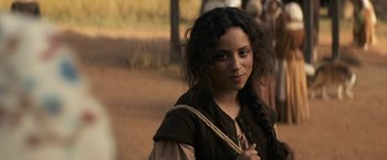 Movie still from “Fear Street: Part Three - 1666” (2021), directed by Leigh Janiak – A woman with long curly black hair wearing a brown vest; Close Up shot, Over the shoulder angle