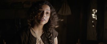 Movie still from “Fear Street: Part Three - 1666” (2021), directed by Leigh Janiak – A woman with long curly brown hair wearing a brown shirt; Close Up shot, Over the shoulder angle