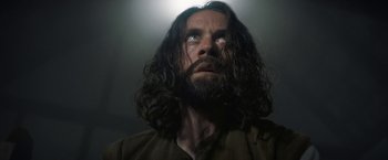 Movie still from “Fear Street: Part Three - 1666” (2021), directed by Leigh Janiak – A man with long hair and a goatee looking upward; Close Up shot, Low angle