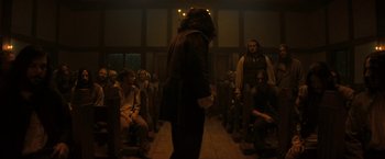 Movie still from “Fear Street: Part Three - 1666” (2021), directed by Leigh Janiak – A group of people sitting in a dark room; Wide shot, Over the shoulder angle