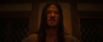 Movie still from “Fear Street: Part Three - 1666” (2021), directed by Leigh Janiak – A man with long black hair and a beard; Close Up shot, Low angle
