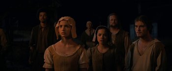 Movie still from “Fear Street: Part Three - 1666” (2021), directed by Leigh Janiak – A group of people standing next to each other in the dark; Medium shot, Over the shoulder angle