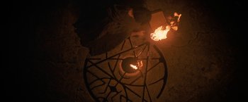 Movie still from “Fear Street: Part Three - 1666” (2021), directed by Leigh Janiak – An overhead view of a person lighting a candle; Wide shot, Overhead angle