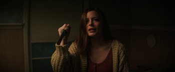 Movie still from “Fear Street: Part Three - 1666” (2021), directed by Leigh Janiak – A woman holding a knife in a dark room; Close Up shot, Low angle
