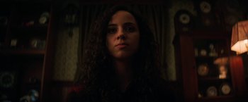 Movie still from “Fear Street: Part Three - 1666” (2021), directed by Leigh Janiak – A woman with long curly brown hair stares into the camera; Close Up shot, Low angle