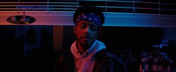 Movie still from “Fear Street: Part Three - 1666” (2021), directed by Leigh Janiak – A man wearing a purple bandana and a black jacket; Close Up shot, Low angle