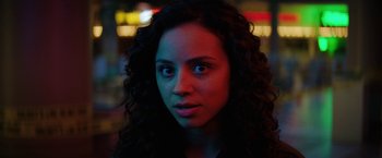 Movie still from “Fear Street: Part Three - 1666” (2021), directed by Leigh Janiak – A person with curly hair; Close Up shot, Over the shoulder angle