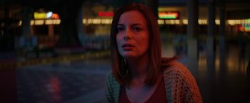 Movie still from “Fear Street: Part Three - 1666” (2021), directed by Leigh Janiak – A woman is standing in the street at night; Close Up shot, Low angle