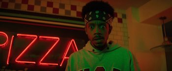 Movie still from “Fear Street: Part Three - 1666” (2021), directed by Leigh Janiak – A young man wearing a crown in front of a neon sign; Close Up shot, Low angle