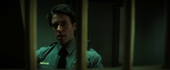 Movie still from “Fear Street: Part Three - 1666” (2021), directed by Leigh Janiak – A man in a uniform looking into a bathroom mirror; Close Up shot, Low angle