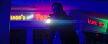 Movie still from “Fear Street: Part Three - 1666” (2021), directed by Leigh Janiak – A man is holding a flashlight in the dark; Medium shot, Low angle