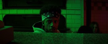 Movie still from “Fear Street: Part Three - 1666” (2021), directed by Leigh Janiak – A man with a bandana on his head is looking at the camera; Close Up shot, Low angle