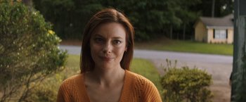 Movie still from “Fear Street: Part Three - 1666” (2021), directed by Leigh Janiak – A person wearing an orange sweater; Close Up shot, Over the shoulder angle