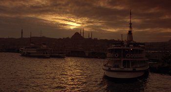 Movie still from “Midnight Express” (1978), directed by Alan Parker – A sunset over the water with a boat in the foreground; Extreme Wide shot, Low angle