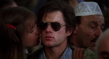 Movie still from “Midnight Express” (1978), directed by Alan Parker – A young man wearing aviator sunglasses and a kiss on the cheek; Close Up shot, Low angle