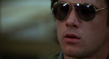 Movie still from “Midnight Express” (1978), directed by Alan Parker – A person wearing sunglasses; Close Up shot, Low angle
