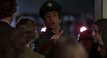 Movie still from “Midnight Express” (1978), directed by Alan Parker – A man wearing a hat is talking to a crowd of onlookers; Close Up shot, Low angle