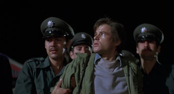 Movie still from “Midnight Express” (1978), directed by Alan Parker – A group of men standing next to each other; Close Up shot, Low angle