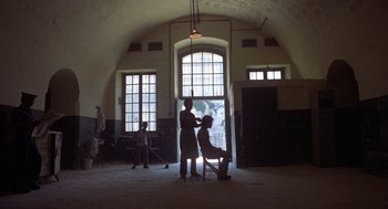 Movie still from “Midnight Express” (1978), directed by Alan Parker – A woman sitting in a chair in front of a man; Extreme Wide shot, Over the shoulder angle
