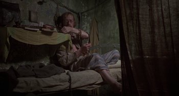Movie still from “Midnight Express” (1978), directed by Alan Parker – A man sitting on a bed in a room; Medium shot, High angle