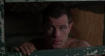 Movie still from “Midnight Express” (1978), directed by Alan Parker – A shirtless man looking out of a window; Close Up shot, Low angle