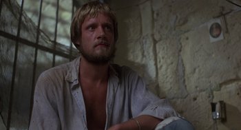 Movie still from “Midnight Express” (1978), directed by Alan Parker – A person sitting on a couch; Close Up shot, High angle